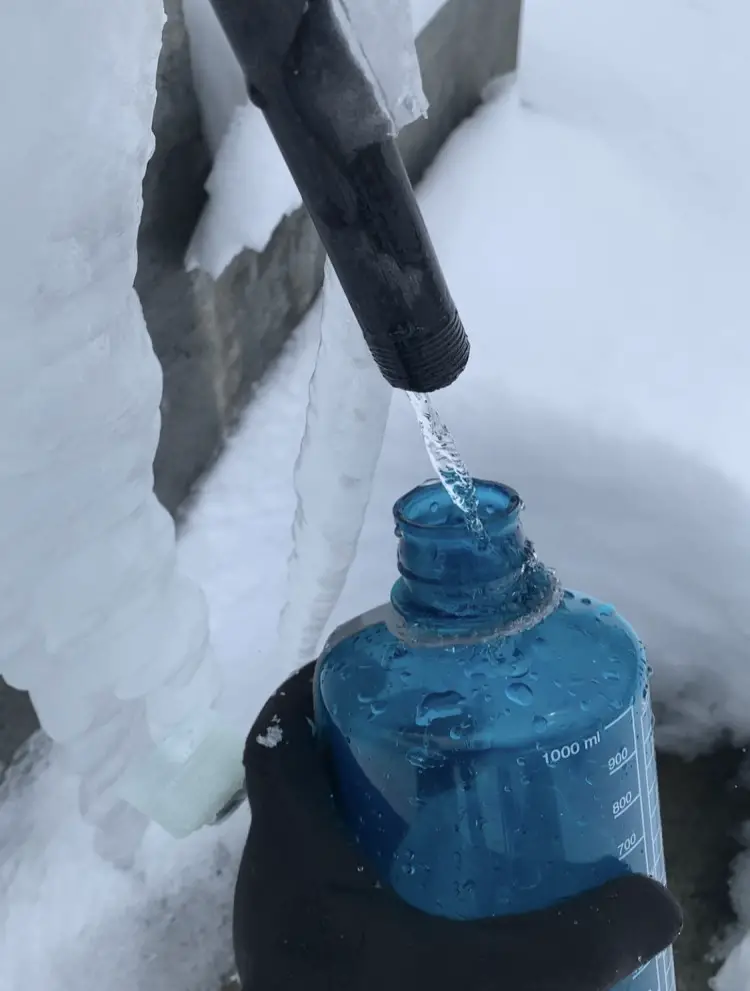 Napełniam butelkę wodą na trasie wokół Annapurny.